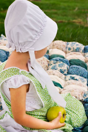 amish child sitting on Amish quilt